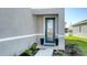 Close up of a stylish front door with glass panel, potted plants, and lush landscaping at 8918 Waxwing Way, Parrish, FL 34219