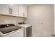 Well-equipped laundry room with modern washer and dryer, plus storage cabinets at 8918 Waxwing Way, Parrish, FL 34219