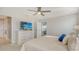 Serene main bedroom with TV and ensuite bathroom featuring a large dresser, plush bed, and an adjacent bathroom at 8918 Waxwing Way, Parrish, FL 34219