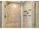 Modern shower features tiled walls, built-in bench, rainfall shower-head, and built-in shelving for organization at 8918 Waxwing Way, Parrish, FL 34219