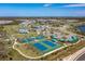 Aerial view featuring the community clubhouse, pool, tennis courts, and landscaped common areas, showcasing an active lifestyle at 10165 Canaveral Cir, Sarasota, FL 34241