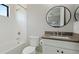 Bright bathroom with a shower/tub combination, gray countertop, and a round mirror at 10165 Canaveral Cir, Sarasota, FL 34241