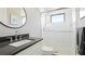 Modern bathroom featuring a walk-in shower with subway tile, a gray vanity and a round mirror at 10165 Canaveral Cir, Sarasota, FL 34241