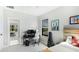 Comfortable bedroom with a work station near the window, and a view into the living room at 10165 Canaveral Cir, Sarasota, FL 34241