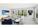 Bright bonus room featuring a large screen TV, white couch, blue chairs and a dart board at 10165 Canaveral Cir, Sarasota, FL 34241