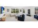 Spacious bonus room with a large screen TV, white couch, blue chairs, and a large window at 10165 Canaveral Cir, Sarasota, FL 34241