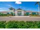 Elegant clubhouse exterior featuring grand columns, blue shutters, and well-manicured landscaping at 10165 Canaveral Cir, Sarasota, FL 34241