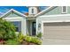 Close-up of the entrance of the home featuring a well-manicured lawn and a two-car garage at 10165 Canaveral Cir, Sarasota, FL 34241
