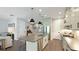 Open-concept kitchen with stainless steel appliances, center island, and modern pendant lighting at 10165 Canaveral Cir, Sarasota, FL 34241