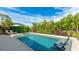 Refreshing swimming pool surrounded by lush landscaping and inviting lounge chairs, perfect for relaxation at 10165 Canaveral Cir, Sarasota, FL 34241