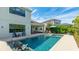 Beautiful backyard featuring a sparkling pool, covered patio, and lush tropical landscaping at 10165 Canaveral Cir, Sarasota, FL 34241