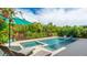 Sparkling pool and spa surrounded by lush tropical landscaping create a serene outdoor oasis at 10165 Canaveral Cir, Sarasota, FL 34241