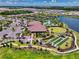 Beautiful aerial view of the clubhouse, pool, bocce ball courts, and surrounding landscaping at 10230 Highland Park Pl, Palmetto, FL 34221