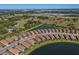 Stunning aerial view of a home nestled beside a tranquil lake in a community surrounded by lush greenery at 10230 Highland Park Pl, Palmetto, FL 34221