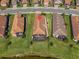 Aerial view of home with a screened in patio, manicured lawn and water view at 10230 Highland Park Pl, Palmetto, FL 34221