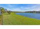 Expansive backyard view with lush green grass and a serene lake, creating a tranquil outdoor space at 10230 Highland Park Pl, Palmetto, FL 34221