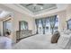 Comfortable bedroom featuring tray ceiling, lake views and slider access to the outside patio at 10230 Highland Park Pl, Palmetto, FL 34221