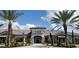 Beautiful community clubhouse with stone accents, lush landscaping, and a covered entrance at 10230 Highland Park Pl, Palmetto, FL 34221