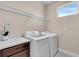 Laundry room with front-loading washer and dryer, storage, and natural light at 10230 Highland Park Pl, Palmetto, FL 34221