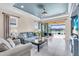 Bright living room with lake views, tile flooring, comfortable sofas, and access to a screened lanai at 10230 Highland Park Pl, Palmetto, FL 34221
