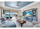 Cozy living room featuring a beautiful lake view, comfortable seating, and a stylish blue entertainment center at 10230 Highland Park Pl, Palmetto, FL 34221