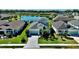 Expansive single-Gathering home with a paver driveway, surrounded by lush landscaping and a tranquil lake at 10527 Falling Leaf Ct, Parrish, FL 34219