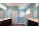 Modern bathroom features dual sinks, a glass shower, and neutral wall and flooring colors at 10527 Falling Leaf Ct, Parrish, FL 34219