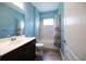 Well-maintained bathroom with a shower-tub combo, white tiling, and a dark wood vanity at 10527 Falling Leaf Ct, Parrish, FL 34219