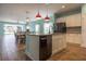 A well-lit kitchen boasts stainless steel appliances, granite countertops, white cabinets, and two pendant lights over the kitchen island at 10527 Falling Leaf Ct, Parrish, FL 34219