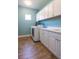 Functional laundry room equipped with a washer, dryer, sink, and ample storage cabinets at 10527 Falling Leaf Ct, Parrish, FL 34219