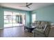 Bright living room with tile flooring, access to the patio, and neutral colored couches at 10527 Falling Leaf Ct, Parrish, FL 34219