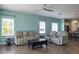 Bright living room with tile flooring, a ceiling fan, neutral couches, and plenty of natural light at 10527 Falling Leaf Ct, Parrish, FL 34219