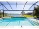 Sparkling swimming pool with lake views in a screened-in lanai at 10527 Falling Leaf Ct, Parrish, FL 34219