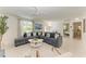 Open living room with a spacious sectional sofa and terrazzo floors, creating a comfortable and stylish space at 116 Hammock Rd, Anna Maria, FL 34216
