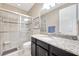 Bathroom with tiled walk-in shower, granite counter, and dark cabinets at 12711 Del Corso Loop, Bradenton, FL 34211