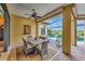 Covered patio featuring a dining area with a view of the pool and lake at 12711 Del Corso Loop, Bradenton, FL 34211