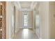 Bright foyer with elegant chandelier, wood-look plank walls, front door with decorative glass, and arched doorways at 12711 Del Corso Loop, Bradenton, FL 34211