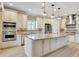 Bright kitchen with white cabinetry, stainless appliances, granite counters and large center island with pendant lighting at 12711 Del Corso Loop, Bradenton, FL 34211