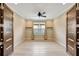 Empty office with light wood floors, a window with shutters, and two large doors at 12711 Del Corso Loop, Bradenton, FL 34211