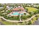 Aerial view of a community pool with lounge chairs, umbrellas, landscaping, and a clubhouse at 12711 Del Corso Loop, Bradenton, FL 34211