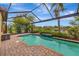 A gorgeous screened pool with brick patio overlooks a peaceful lake and beautiful tropical foliage at 12711 Del Corso Loop, Bradenton, FL 34211