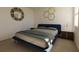Comfortable bedroom featuring a blue platform bed, modern nightstands, and soft lighting at 13040 Cedar Elm Lane, Parrish, FL 34219