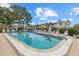Relaxing community pool featuring lounge chairs, mature trees, and well-maintained landscaping at 1536 Leisure Dr # N4, Bradenton, FL 34207