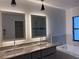 Modern bathroom featuring dual sinks, marble countertops, illuminated mirrors, and a luxurious soaking tub at 1541 Music Ln, North Port, FL 34286