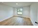 Cozy bedroom with wood-look floors and a large window offering a view of the outdoors at 1541 Music Ln, North Port, FL 34286