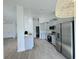 Modern kitchen with stainless steel appliances, gray cabinets, and an open layout to the home at 1541 Music Ln, North Port, FL 34286