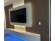 Modern living room featuring an accent wall with mounted TV and custom lighting details at 1541 Music Ln, North Port, FL 34286