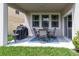 Covered patio with dining set, grill and a lush green lawn at 1570 Ludington Ave, Wesley Chapel, FL 33543