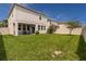 Spacious backyard with covered patio, lush green lawn, and a privacy fence at 1570 Ludington Ave, Wesley Chapel, FL 33543