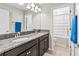 Bathroom with double sink vanity, granite countertops, and a tub/shower combo at 1570 Ludington Ave, Wesley Chapel, FL 33543